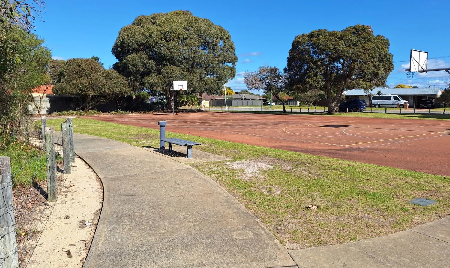 Park bench facing outdoor basketball courts